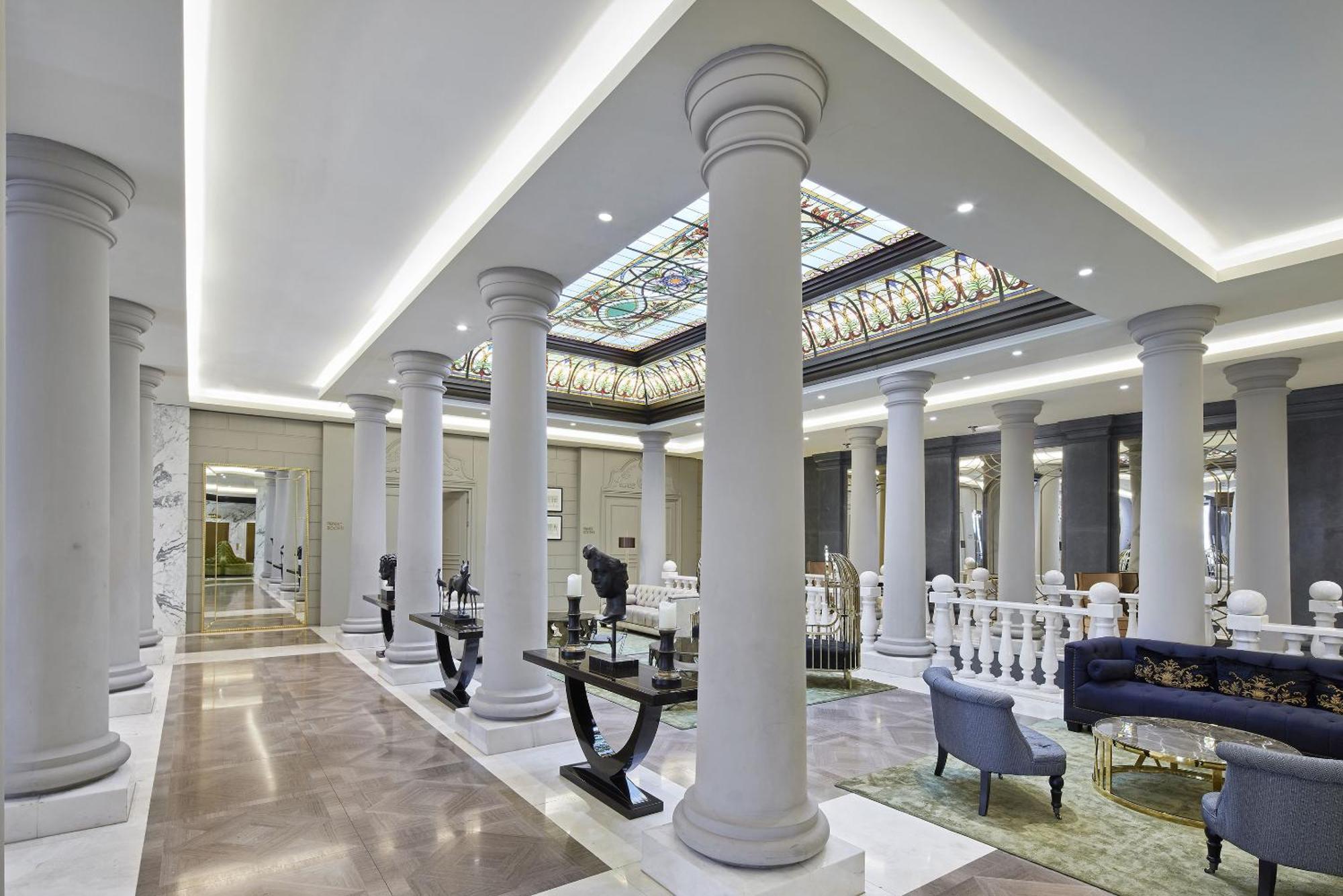 ไททานิค เกนดาร์เมนมาร์ค เบอร์ลิน โฮเทล Hotel ภายนอก รูปภาพ The photo depicts an elegant interior space, likely a lobby or a grand hall. It features tall, decorative columns that line the area, creating a sense of grandeur. The ceiling is adorned with intricate designs and stained glass, allowing light to fil